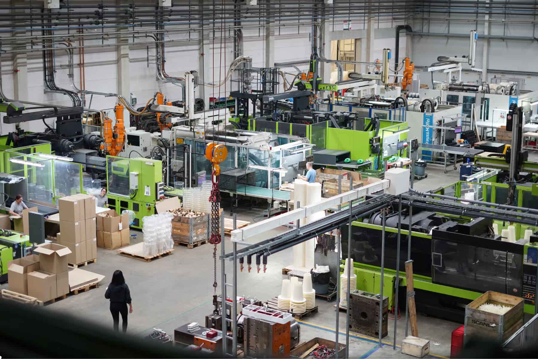 PolyTALENT Personalberatung für Produktion und Industrie Produktionshalle im deutschen Mittelstand mit Maschinen, Förderband und Fachkräften im Schichtbetrieb