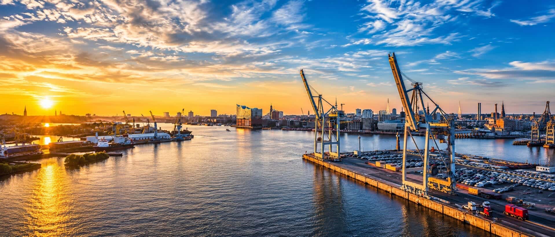Hamburger Hafen mit Containerbrücken und Elbphilharmonie im Abendlicht